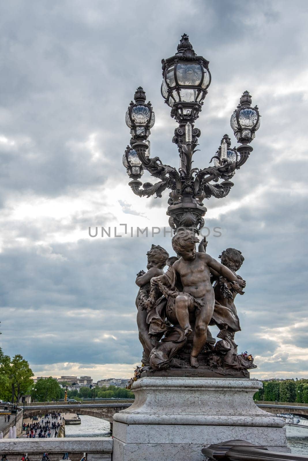 Ornate classicist Street Light with three Cherub on bridge Alexandre III, Paris, France