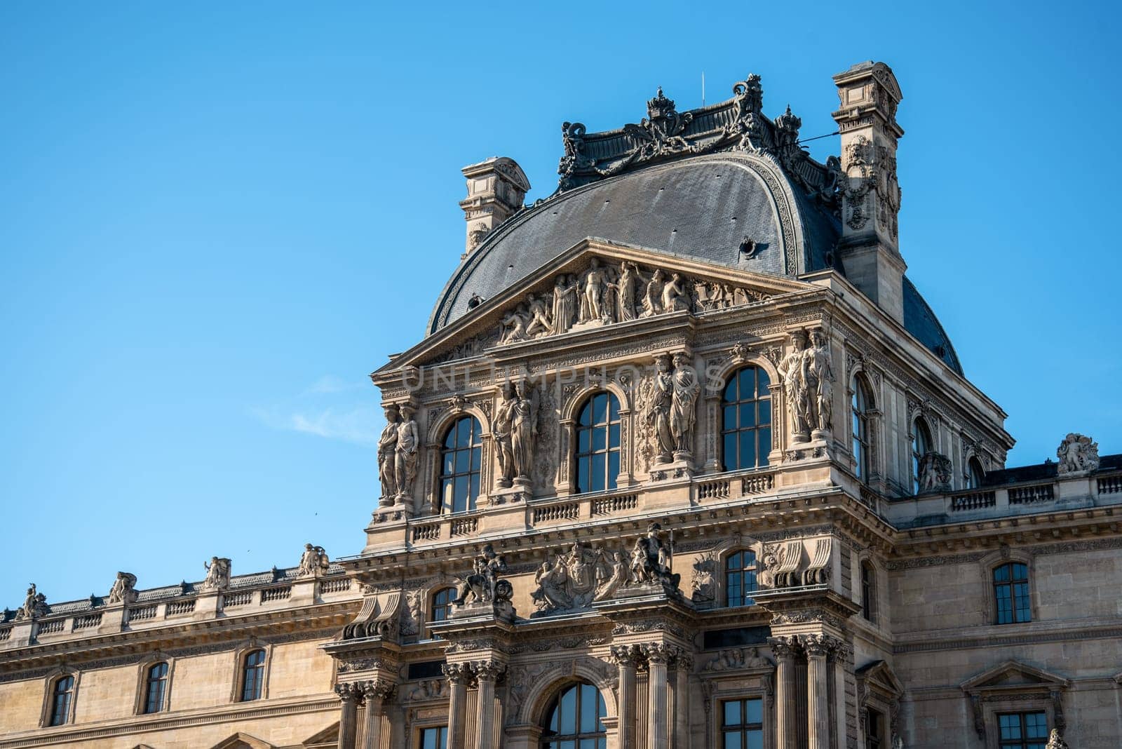 Detail of the left wing facade of Louvre Palace on a sunny summer day in Paris, France