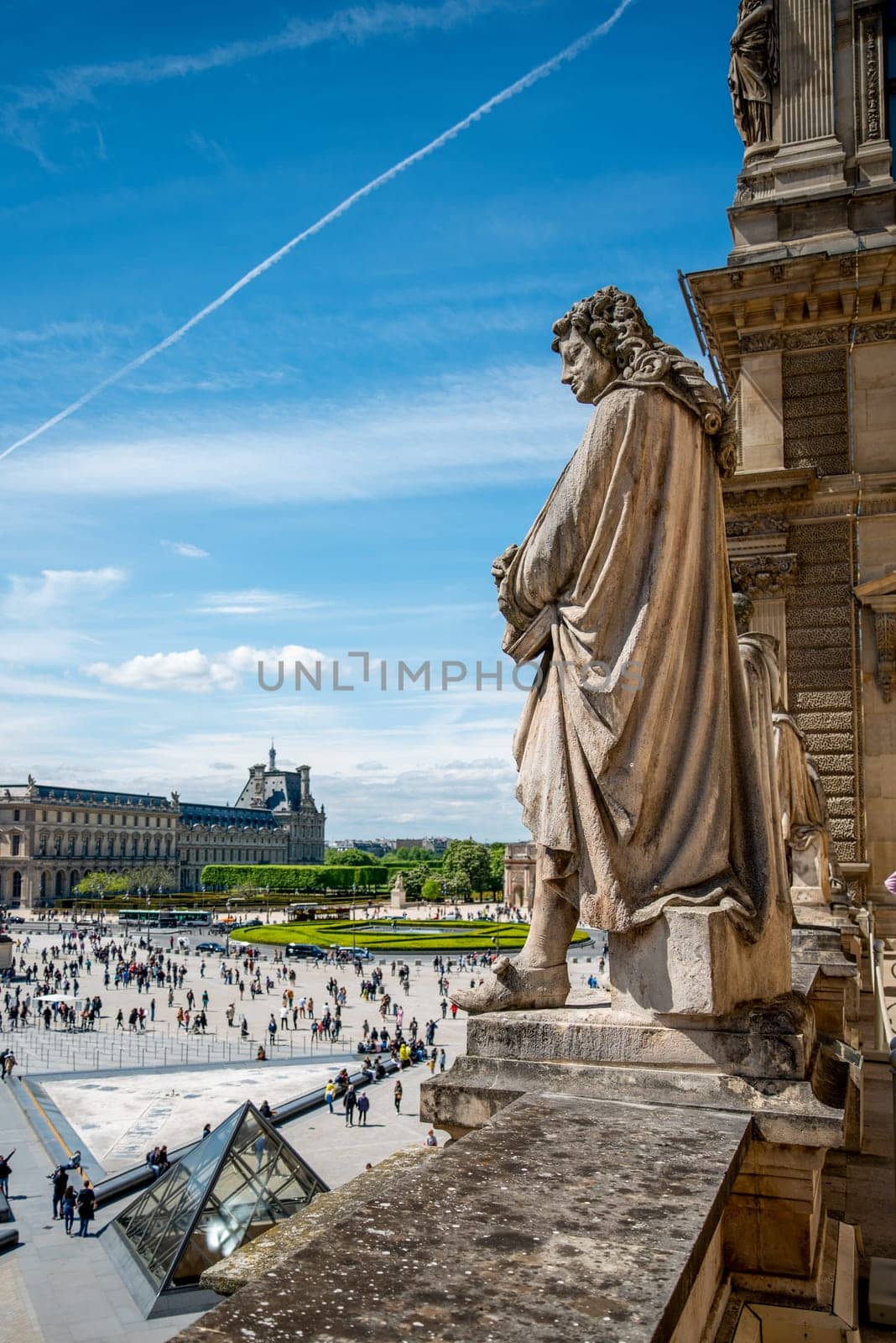 Statue looking down at the Square of Louvre Palace, Paris France