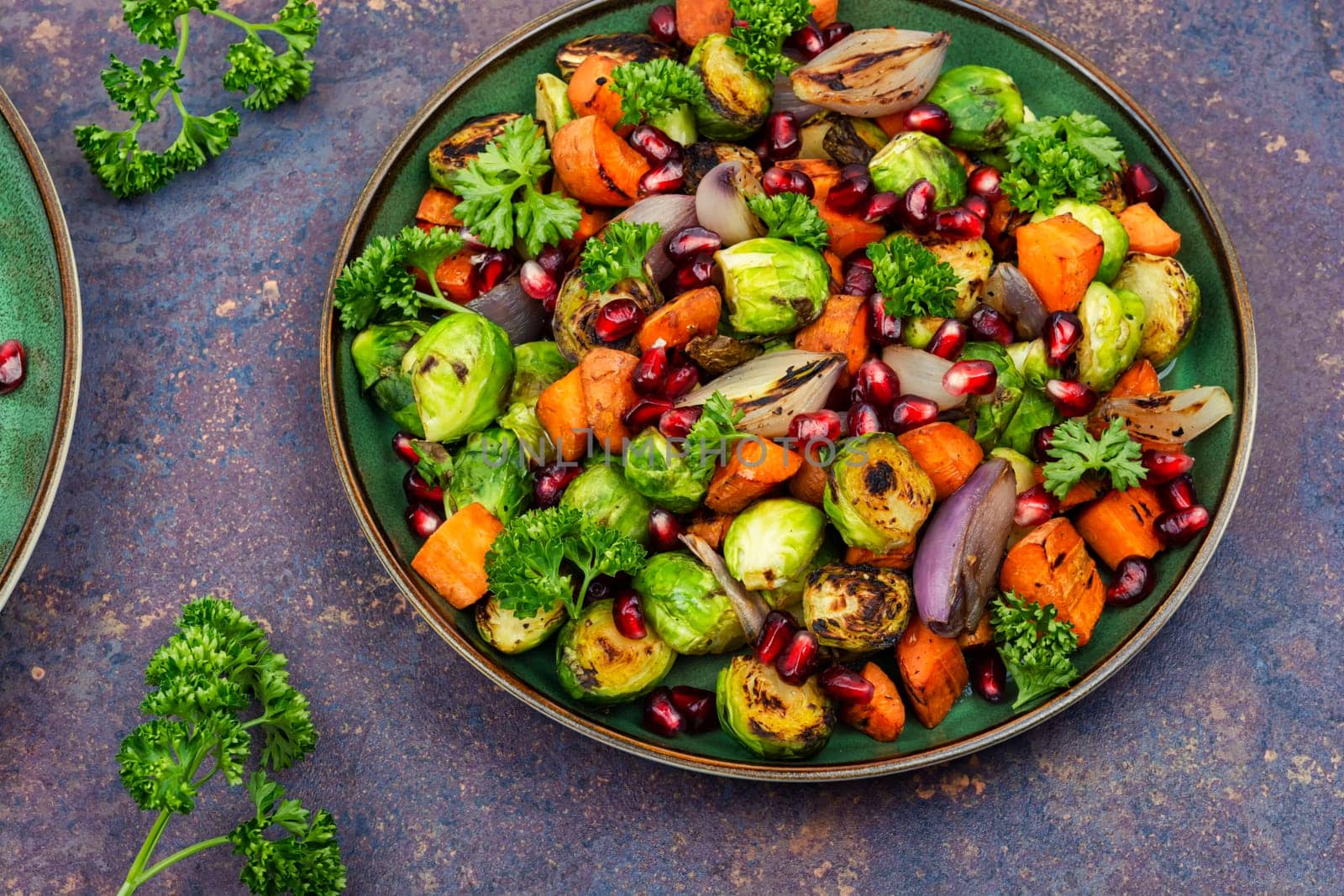 Salad with Brussels sprouts, carrots, with parsley and pomegranate seeds. Healthy vegetarian food