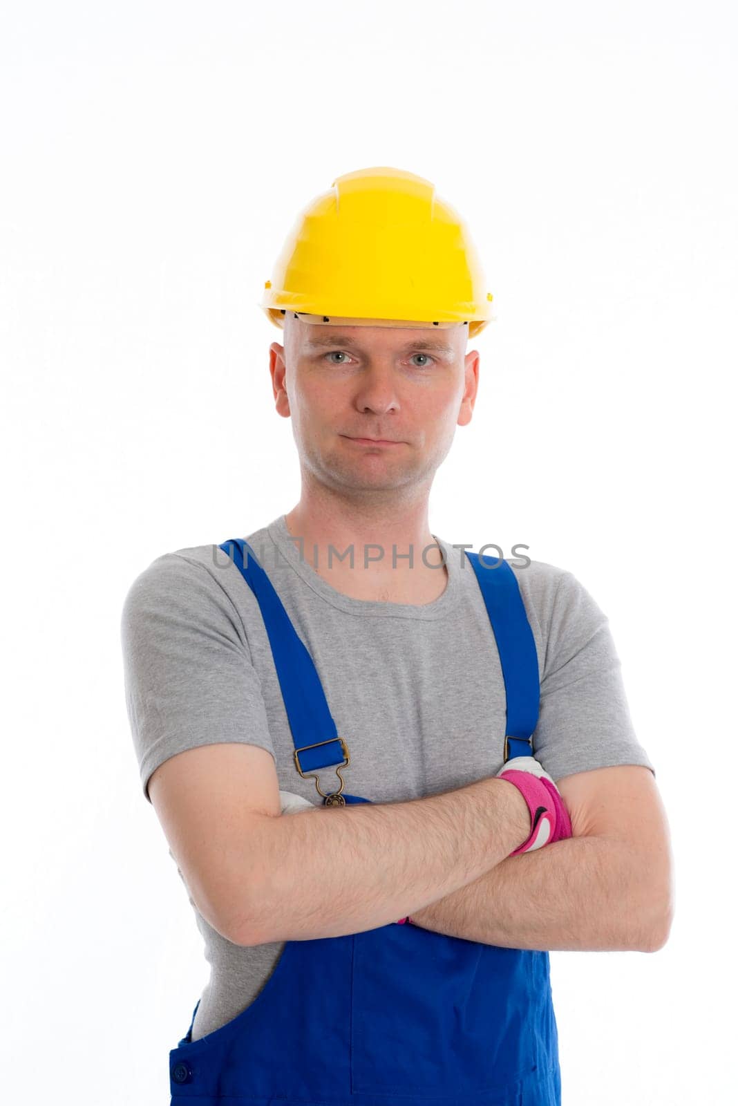 young workman in blue dungarees and yellow hard top