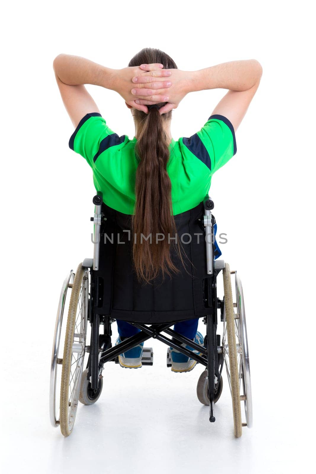 young man in a wheelchair in front of white background from the back