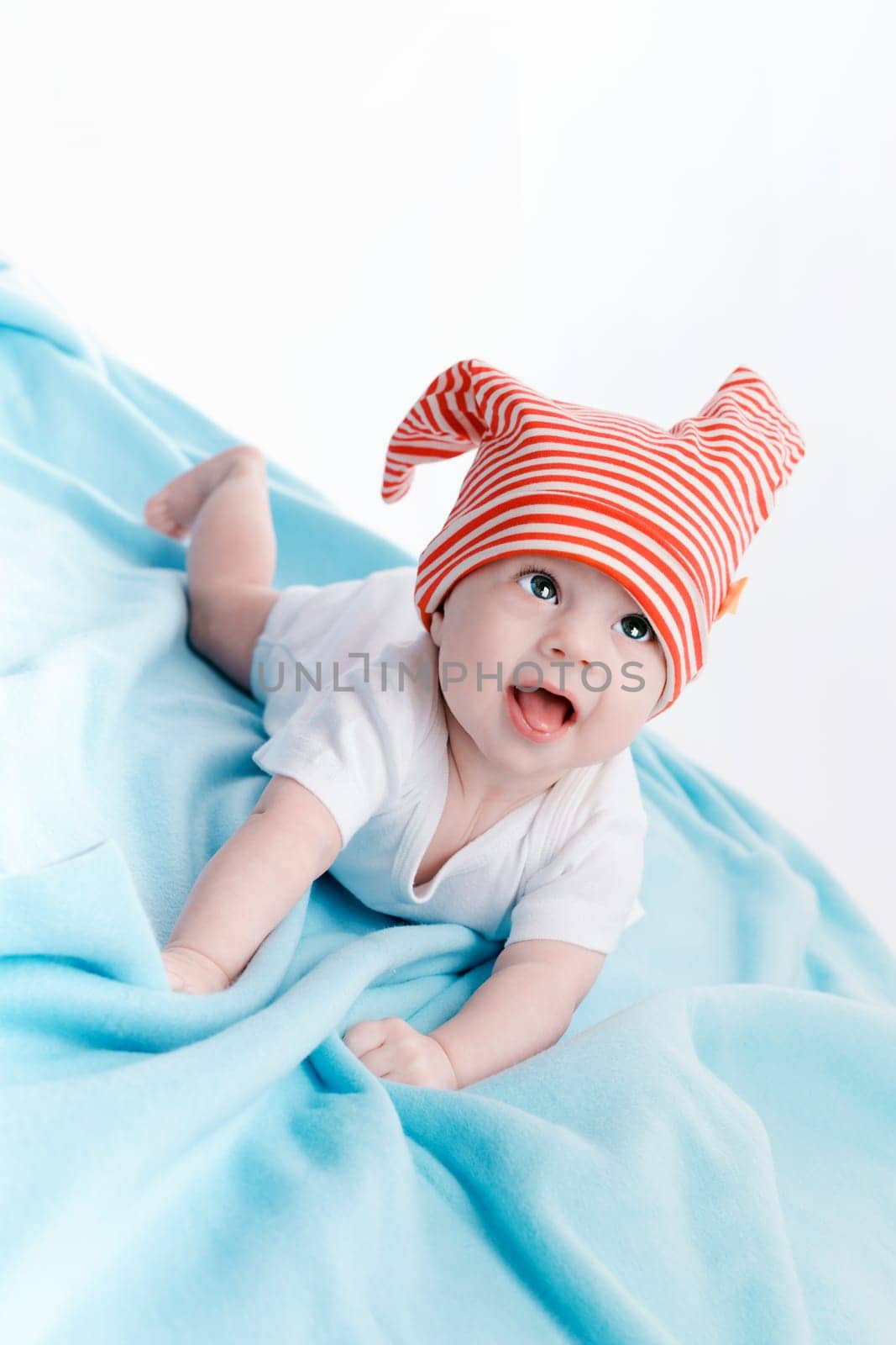 Baby in hat lying on a blue plaid