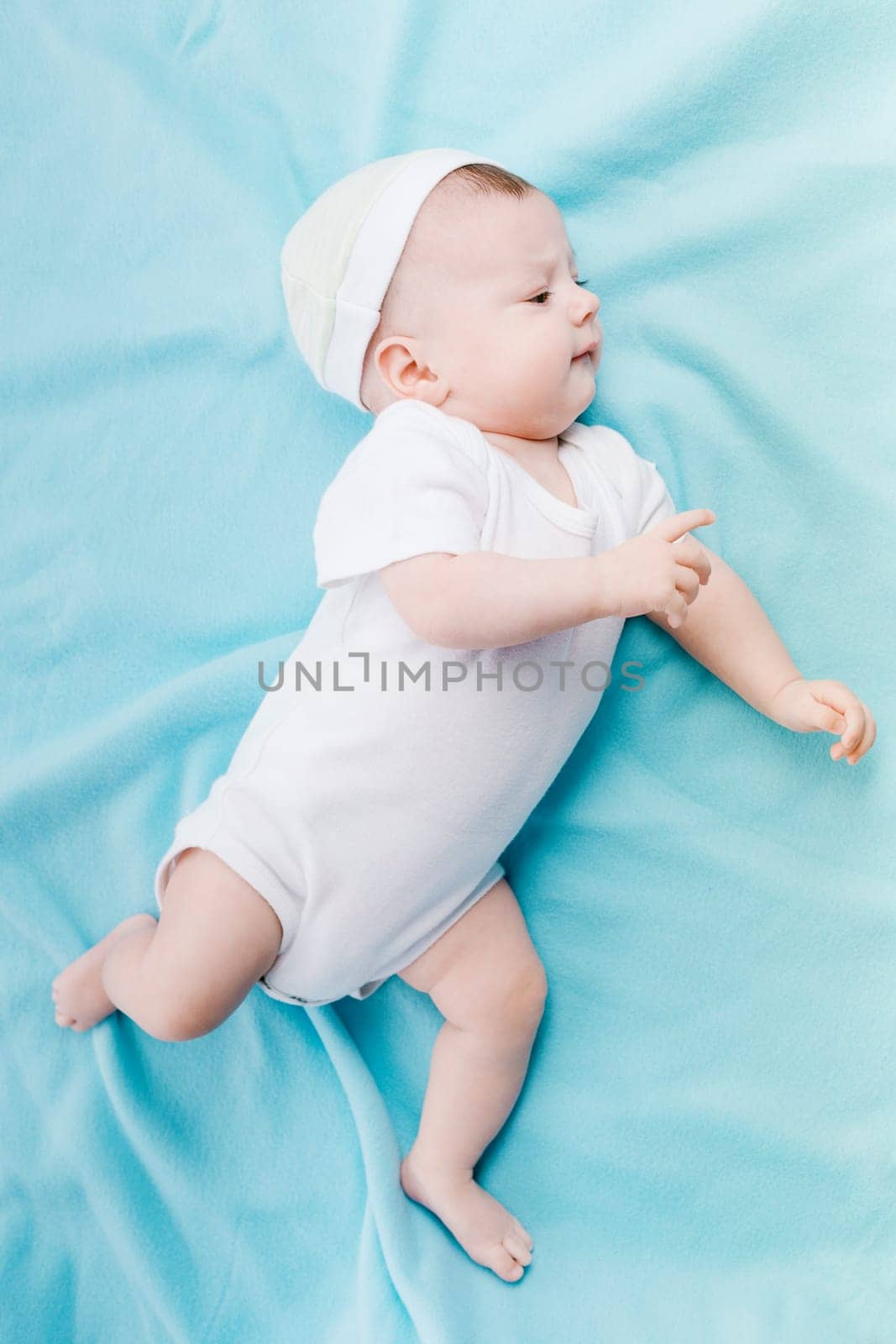 Baby in hat lying on a blue plaid