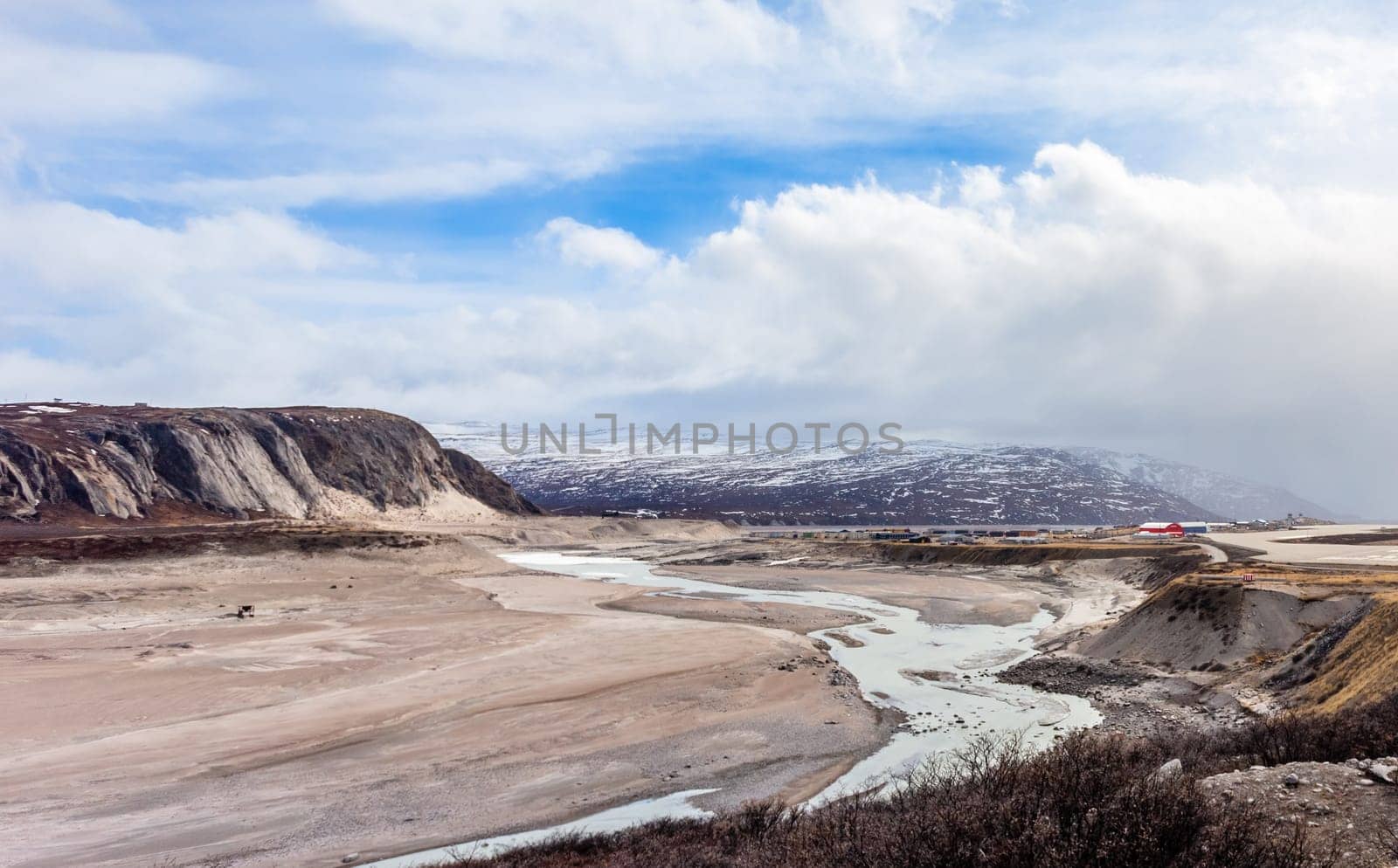 Autumn greenlandic wastelands landscape with glacier river bend and mountains in the background, Kangerlussuaq, Greenland