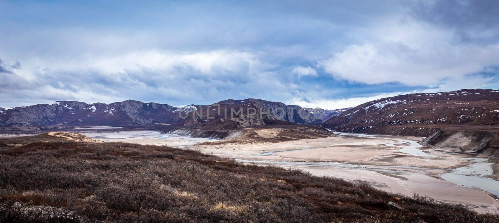 Greenlandic wastelands landscape with river and mountains in the background, Kangerlussuaq, Greenland
