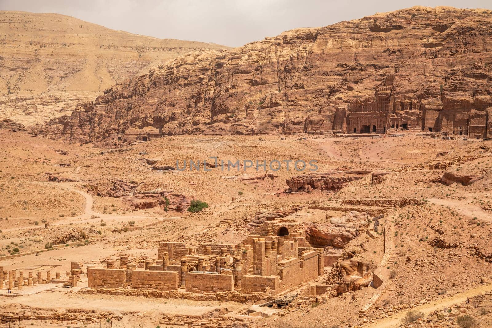 Ancient Nabataean Royal tombs in the background and ruins of grand temple in the foreground, Petra, Jordan