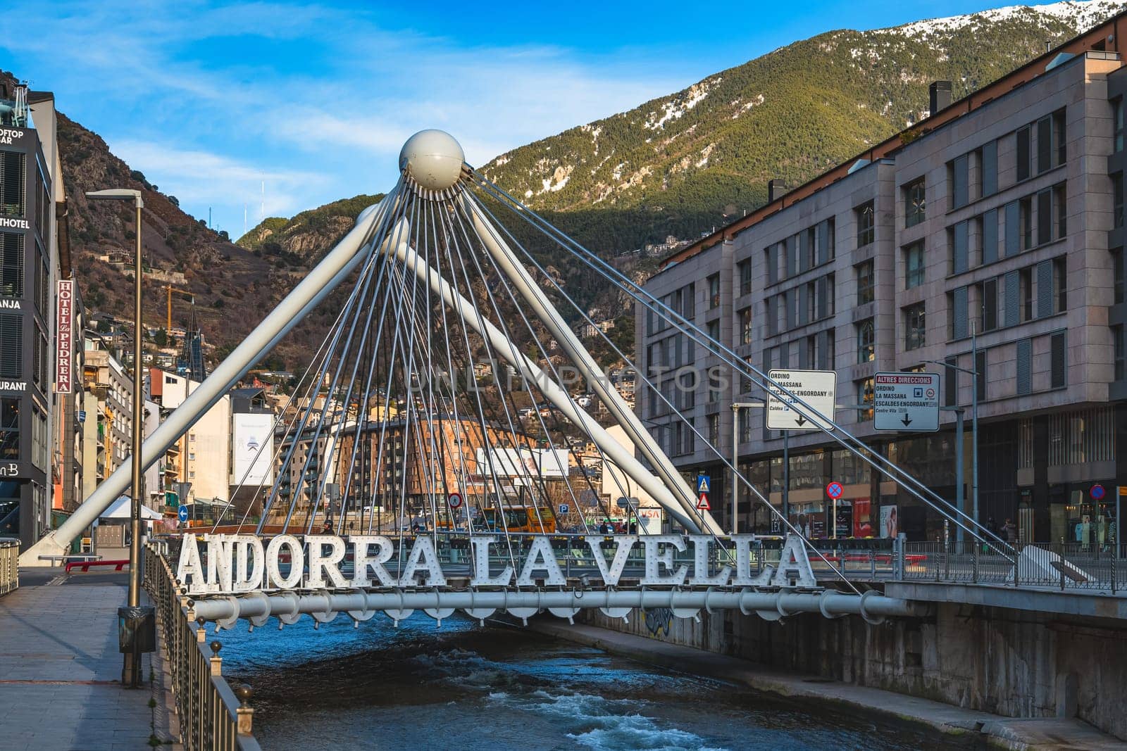 Andorra la Vella, Jan 2020 Pont de Paris bridge crossing Gran Valira river in capital of Andorra with Pyrenees Mountains in the background