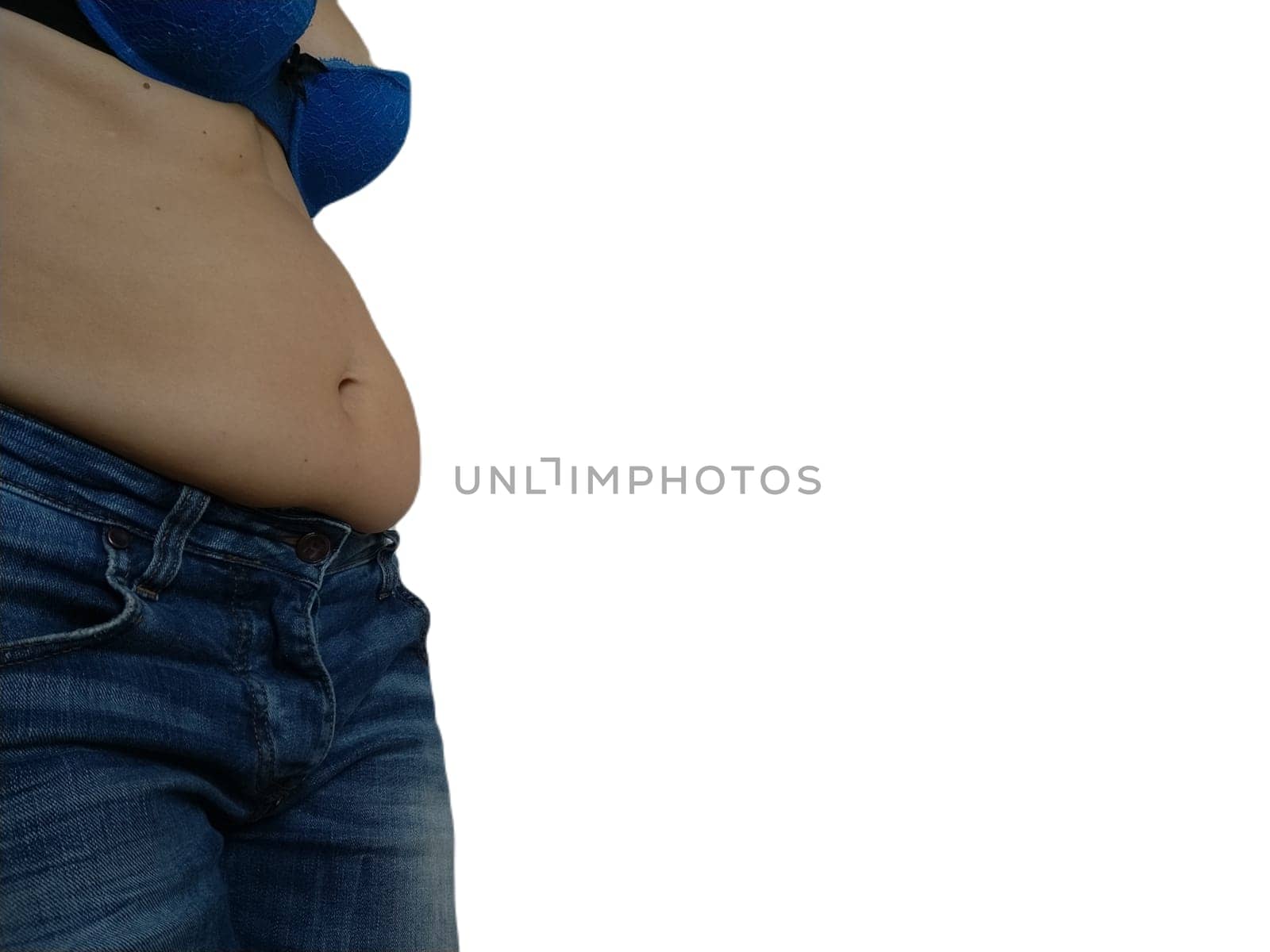 Saggy belly. Folds of leather and fat on the sides hanging over the waist of the jeans. A figure spoiled by overeating or pregnancy. Obesity and Diabetes. White background. Cellulite flabby muscles.