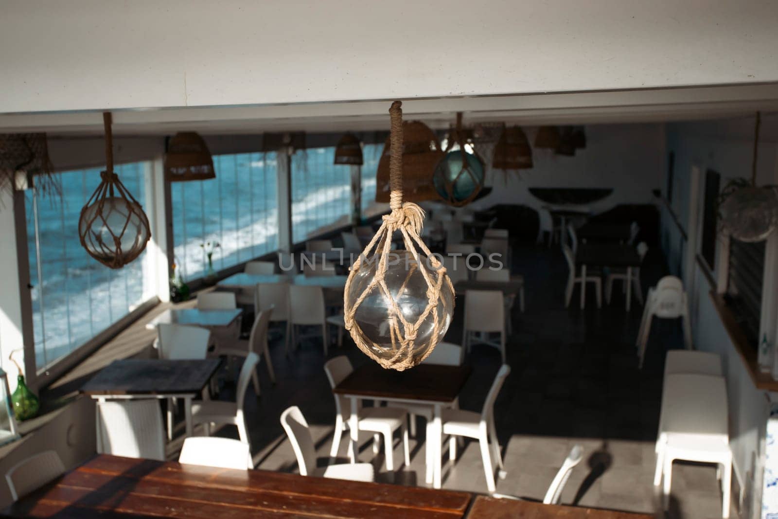 Cozy terrace on the beach, idyllic view of the seashore. Tropical summer vacation concept.
