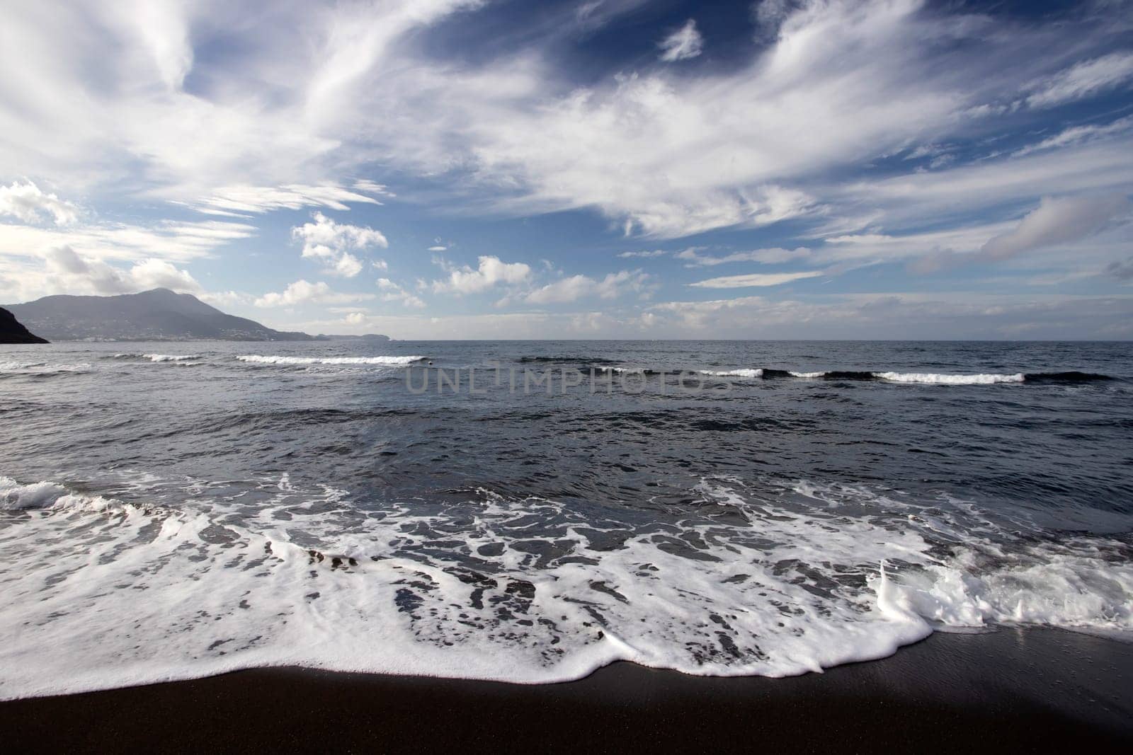 View of Ciraccio beach with black sand and clear water, Procida, Italy