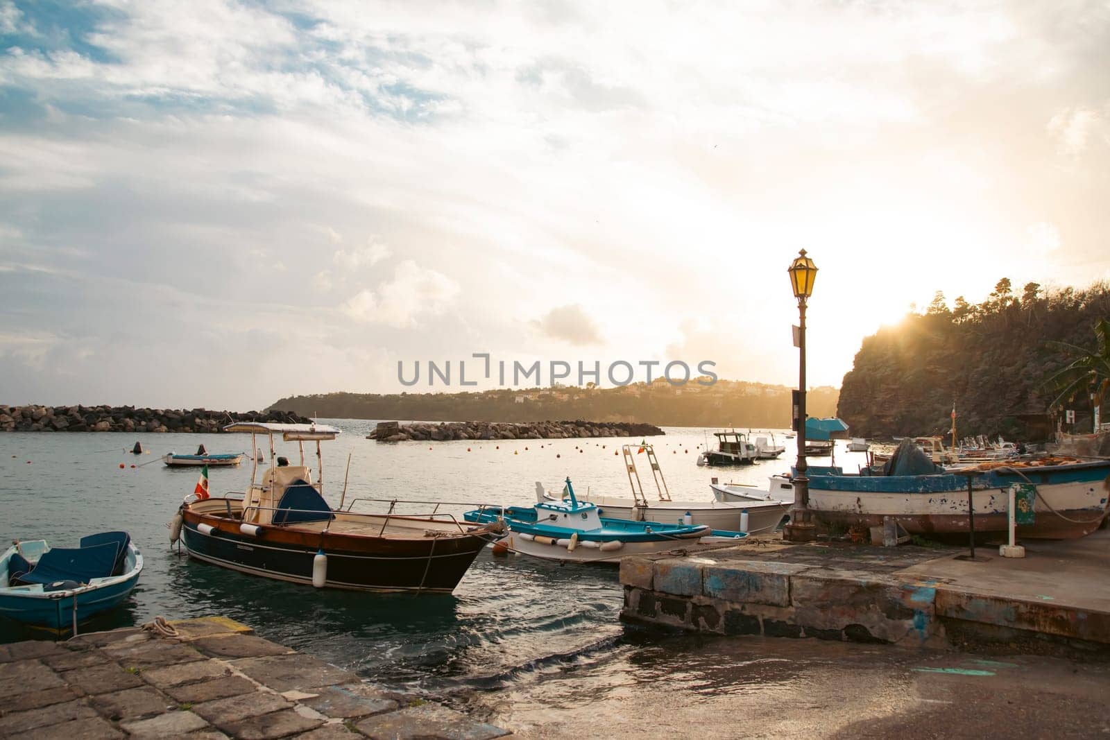 View of the Port of Corricella with lots of colorful houses on a sunny day in Procida Island, Italy.
