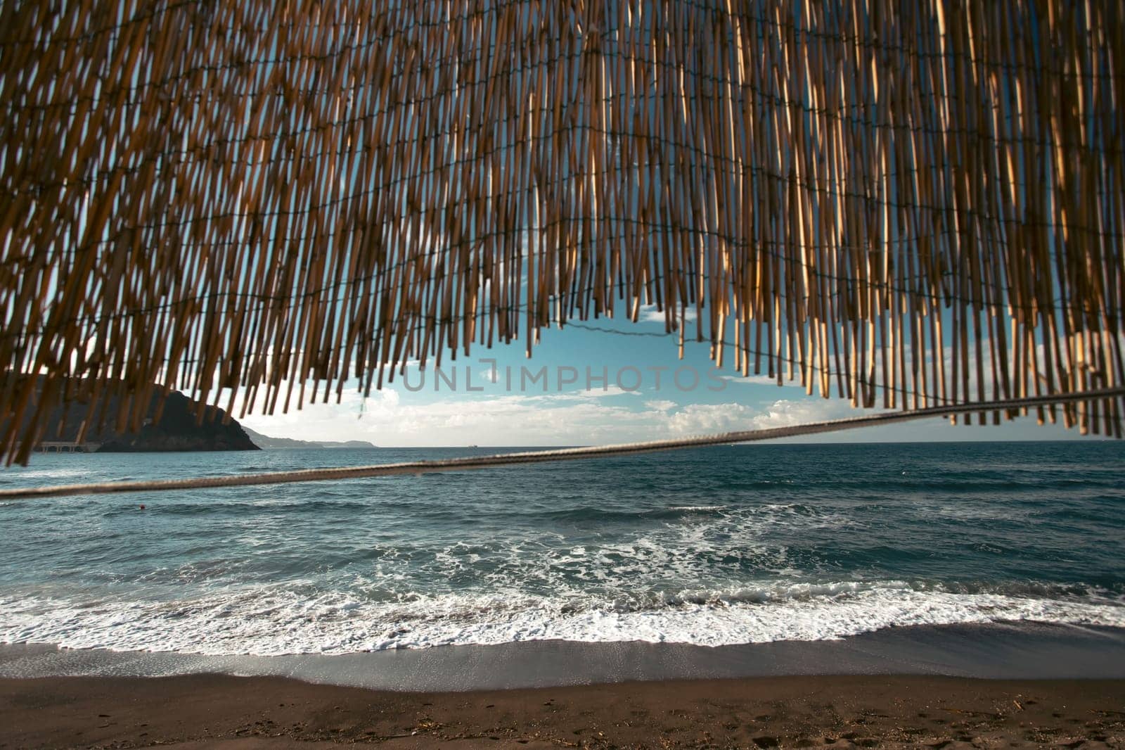 Cozy terrace on the beach, idyllic view of the seashore. Tropical summer vacation concept.