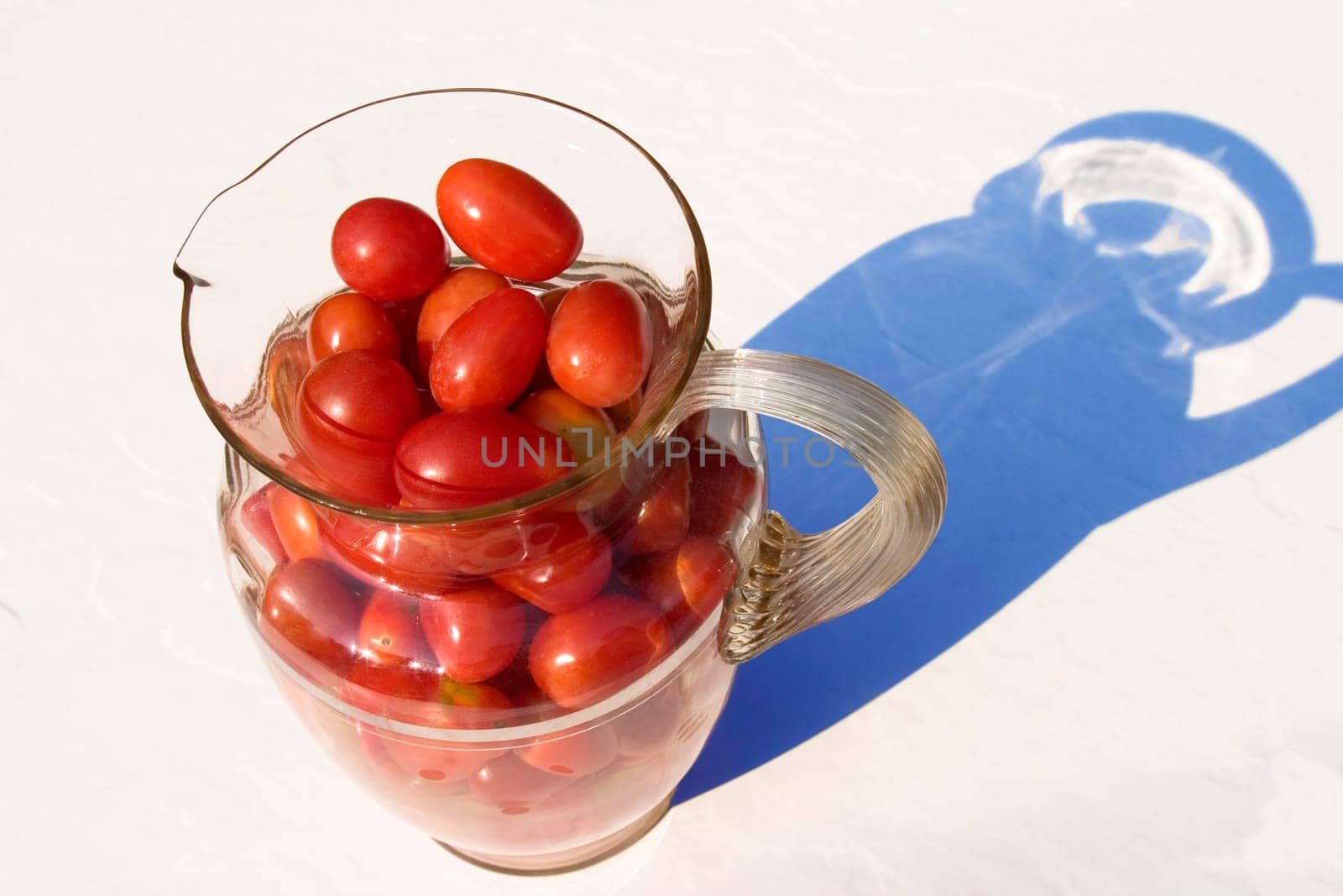Cherry tomatoes in a glass pitcher.