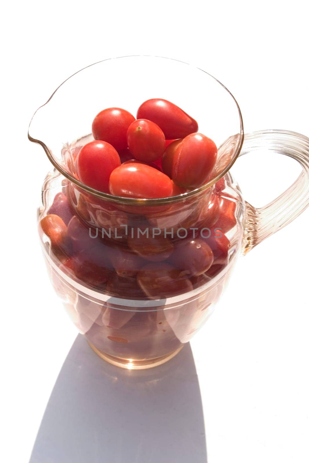 Cherry tomatoes in a glass pitcher.