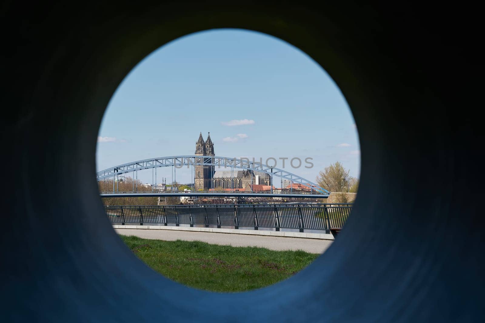 View of Magdeburg Cathedral and Stern Bridge through the hole of a sculpture on the bank of the Elbe River near Magdeburg, Germany