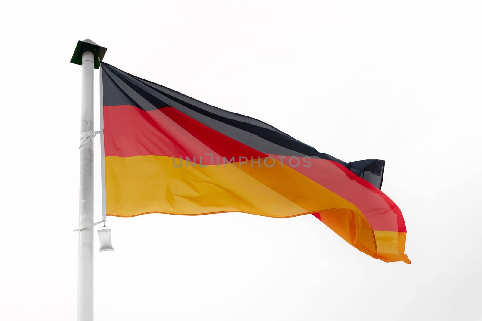 German flag waving in the wind on a flagpole with a white background