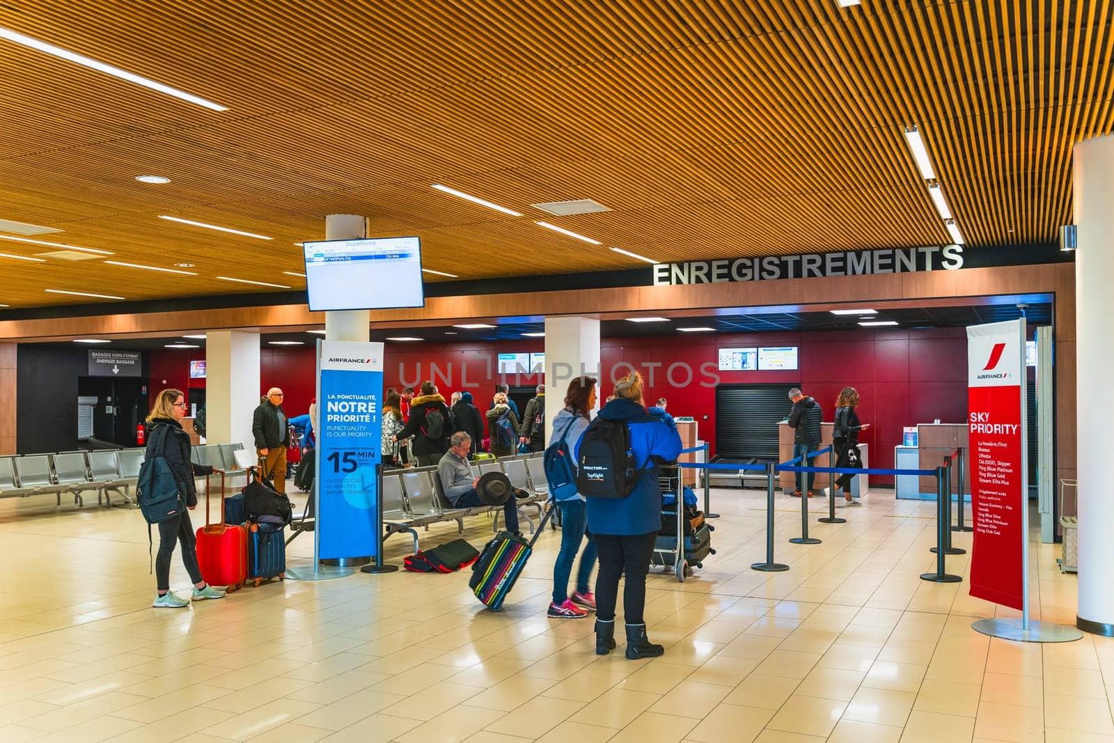 Perpignan, France, Jan 2020 People, tourists standing with luggage in a queue for check in and flight departure, Mediterranean airport