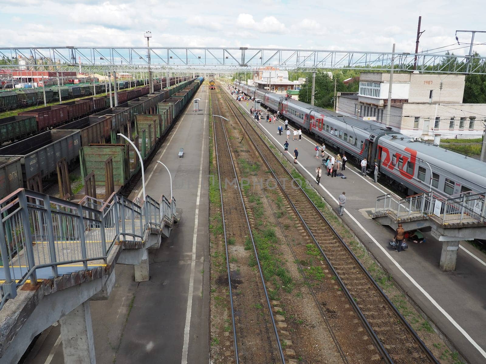 Svir, Russia, August 6, 2021. Railway station top view. People get off the trains. District railway station of the Oktyabrskaya railway. Docking station for two types of electric traction.
