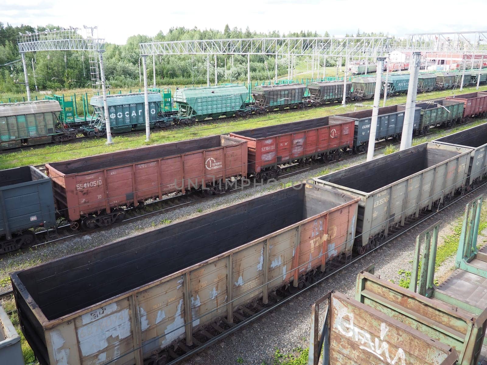 Svir, Russia August 6, 2021. Freight trains and wagons from above. Railroad on a summer day. Transportation, cargo, logistics and business process. Empty metal wagons. International cargo transport.