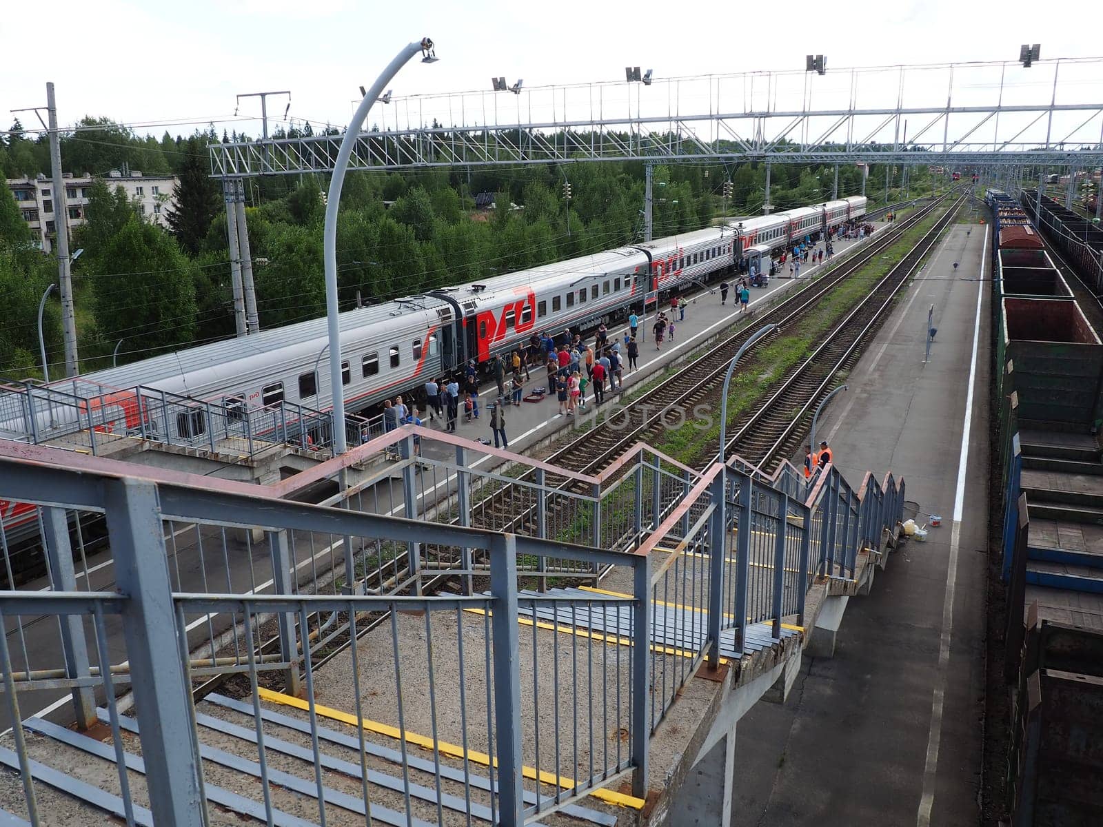 Svir, Russia, August 6, 2021. Railway station top view. People get off the trains. District railway station of the Oktyabrskaya railway. Docking station for two types of electric traction.