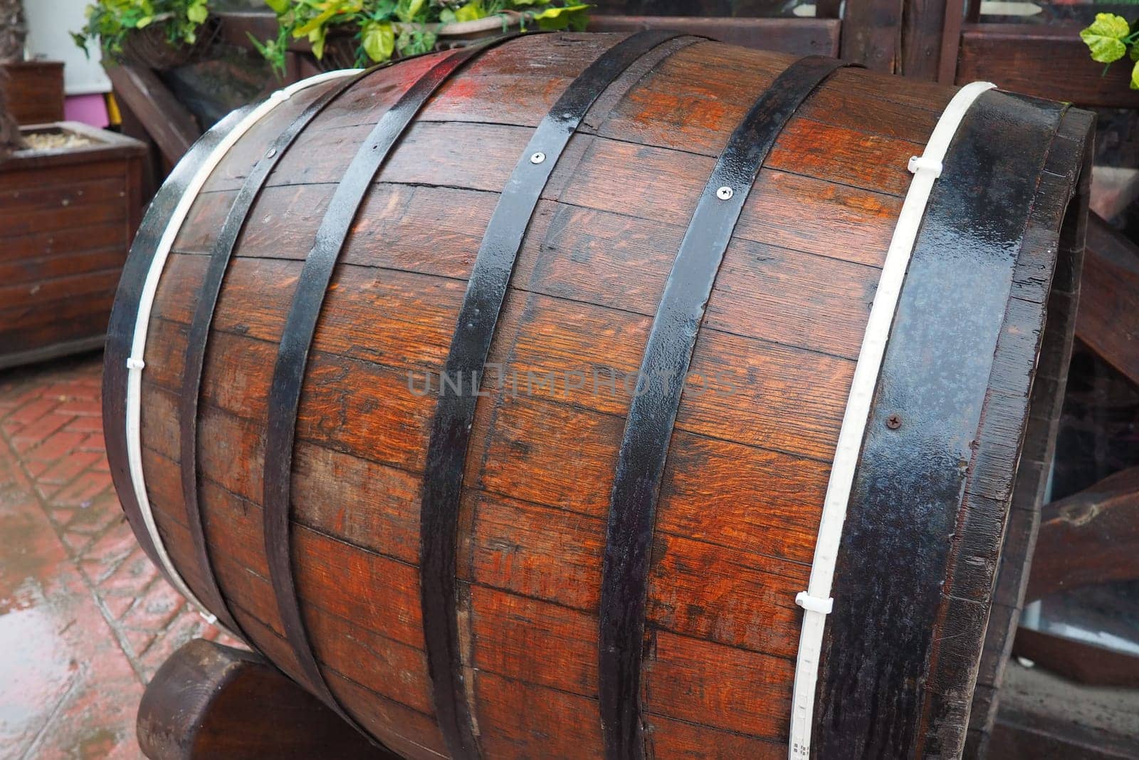 A traditional old wooden barrel with curved walls and metal hoops. Dishes for the ripening of alcoholic beverages - mead, beer, wine, whiskey. A rollable cylindrical vessel for liquid substances