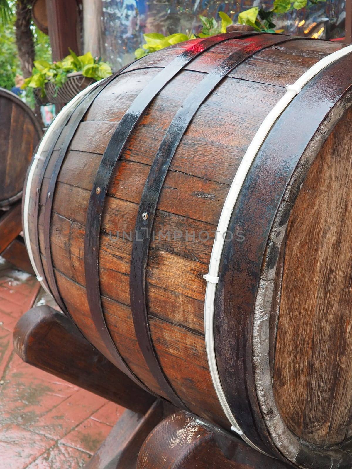 A traditional old wooden barrel with curved walls and metal hoops. Dishes for the ripening of alcoholic beverages - mead, beer, wine, whiskey. A rollable cylindrical vessel for liquid substances
