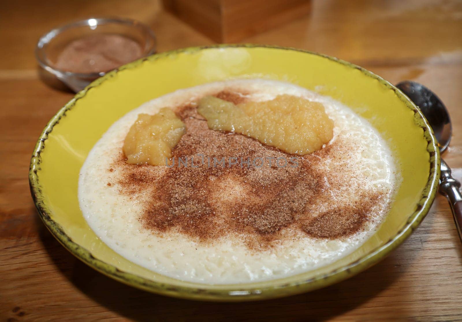 A plate of porridge, applesauce, and cinnamon and sugar.