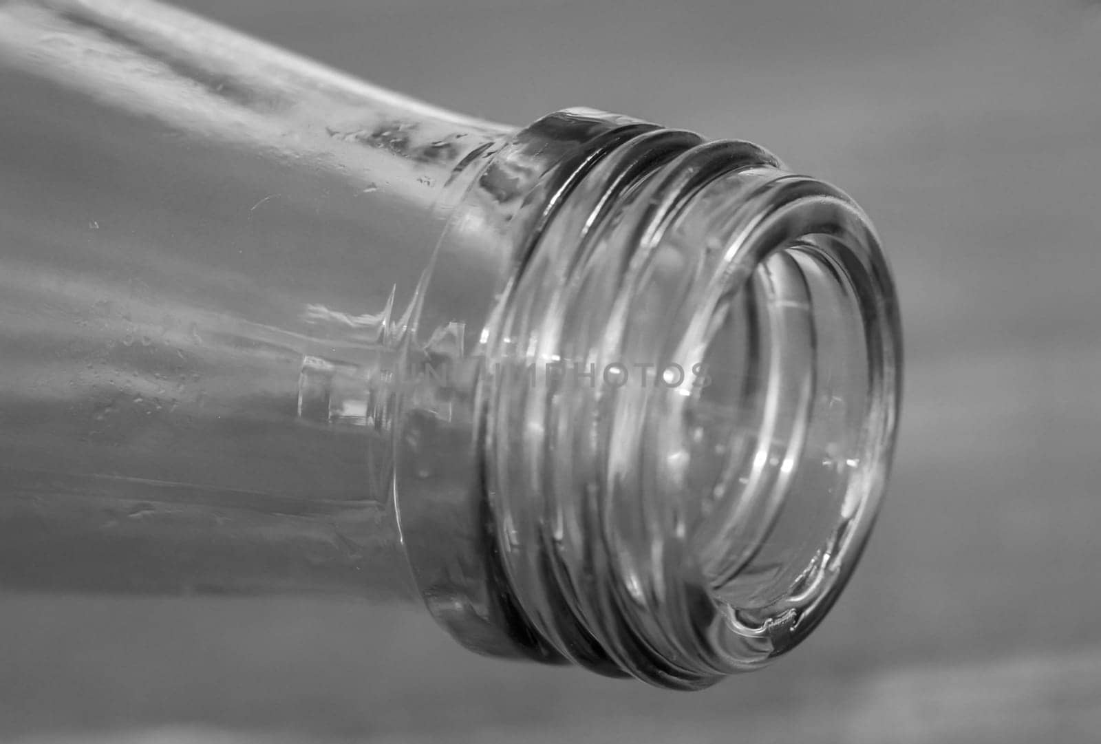 A close-up of a neck of a glass bottle for beverages.