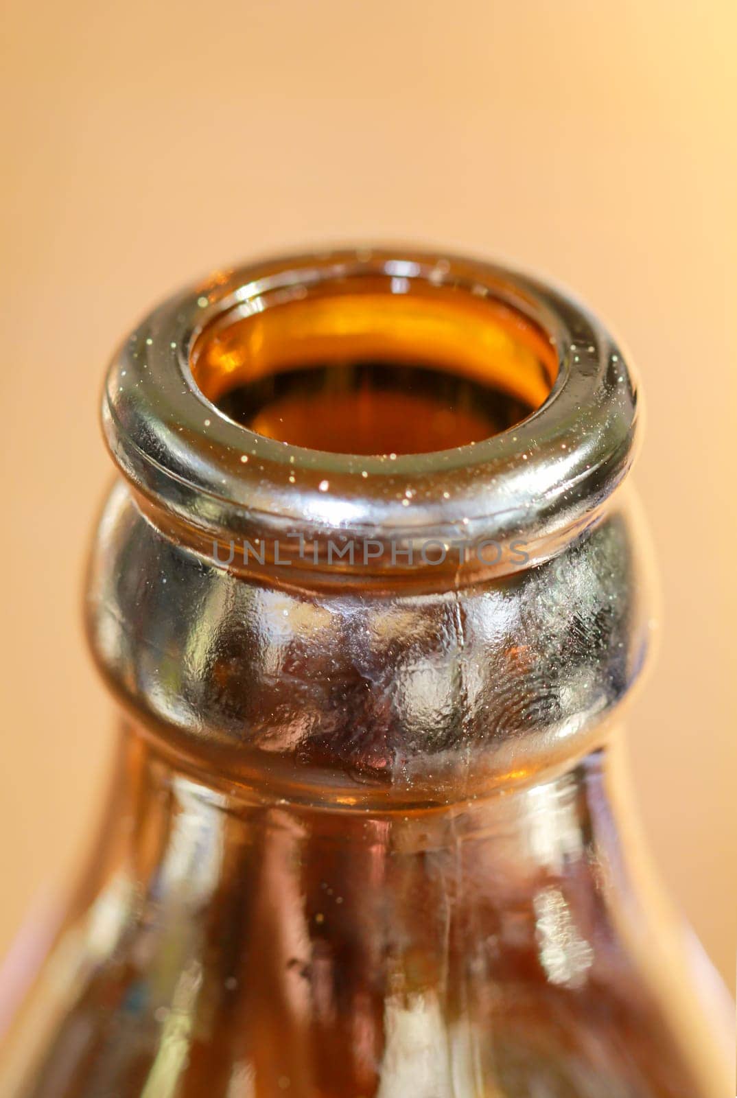 A close-up of a neck of a glass bottle for beverages.