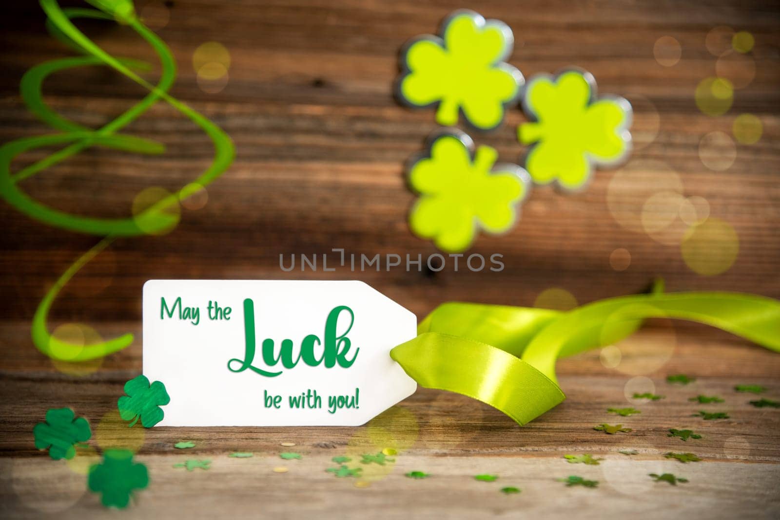 White Label With English Text May Be The Luck With You. Saint Patrick's Day Decoration With Green Shamrock And Clover. Wooden Vintage Background With Festive Ribbon.