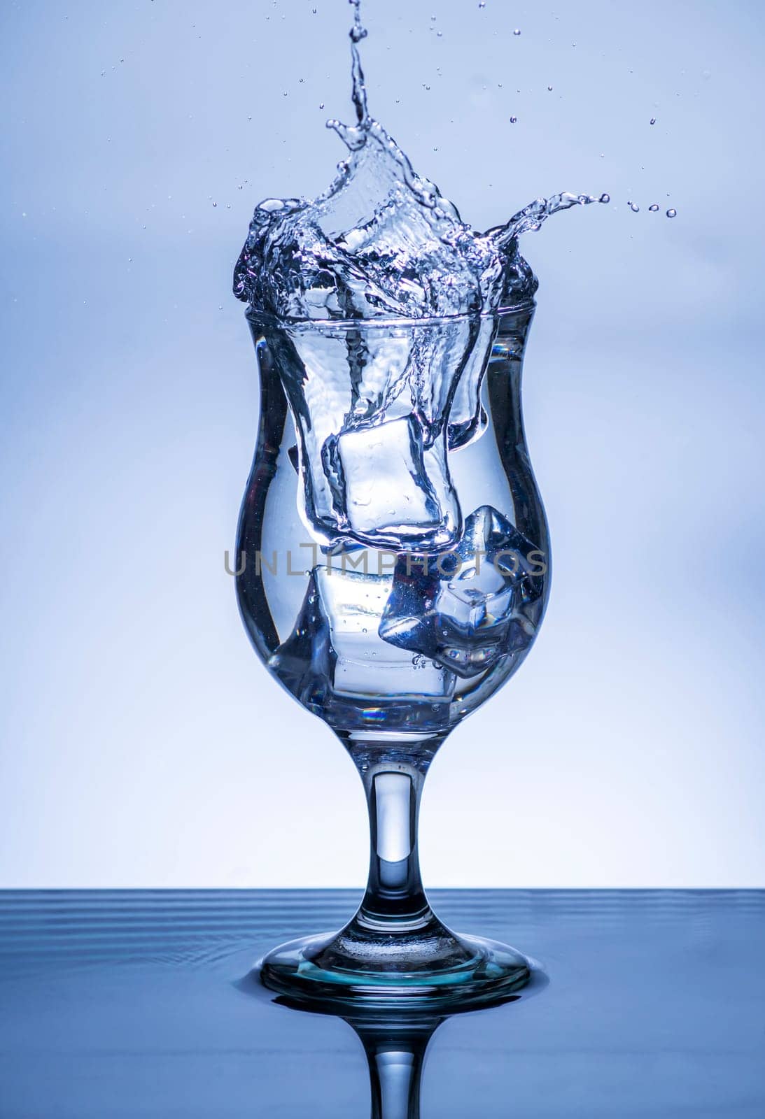 The image of pouring drinking water, into a glass, that makes one feel refreshed on blurred white background, Splashing water, Sparkling water