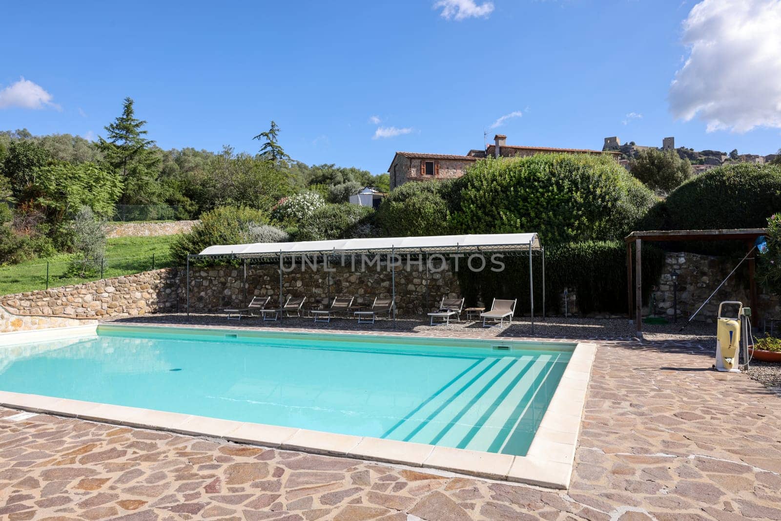 A swimming pool on the Montemassi hillside surrounded by cypresses and oleanders n the province of Grosseto. Italy