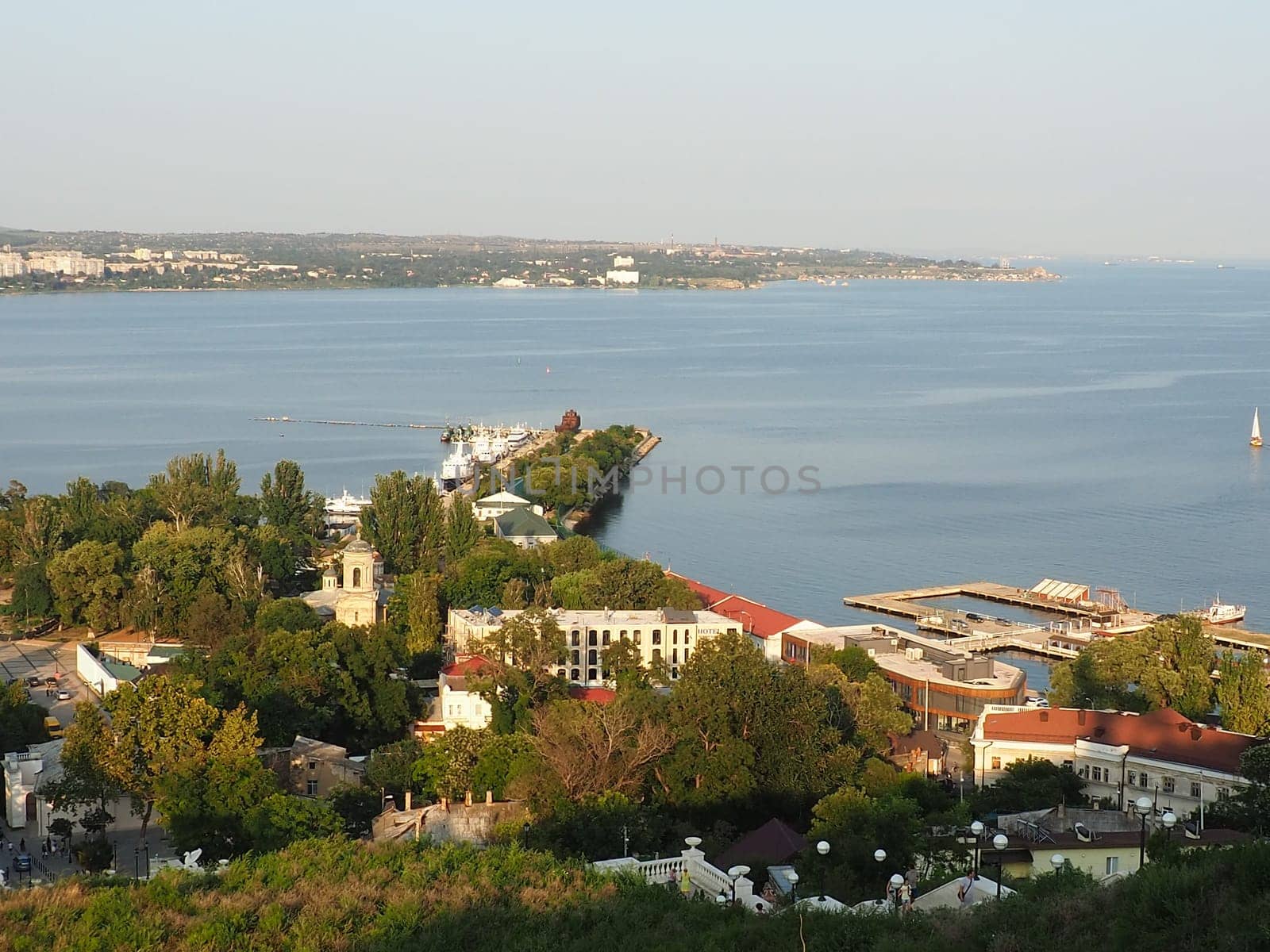 Kerch August 21, 2021 View of the city of Kerch from the observation deck on Mount Mithridat. Houses, trees, Black and Azov seas, seaport. Cove and opposite shore with horizon. Summer evening.