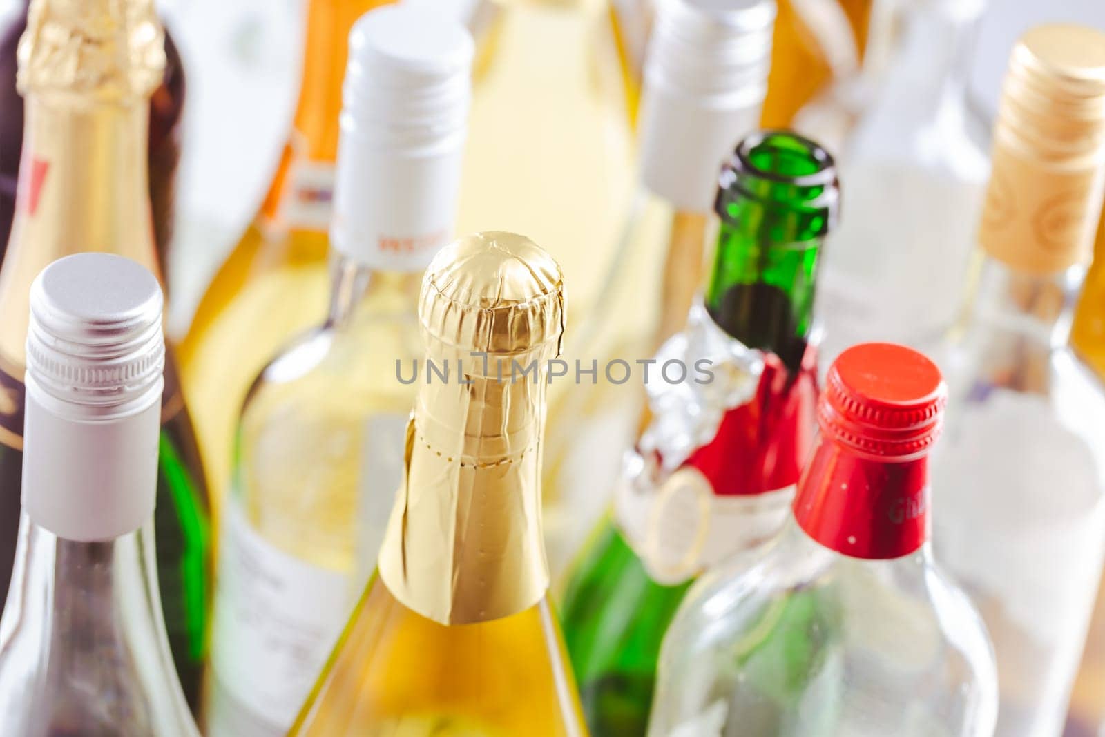 Full and empty bottles of different alcoholic drinks, abuse and alcohol addiction. Alcoholism concept.