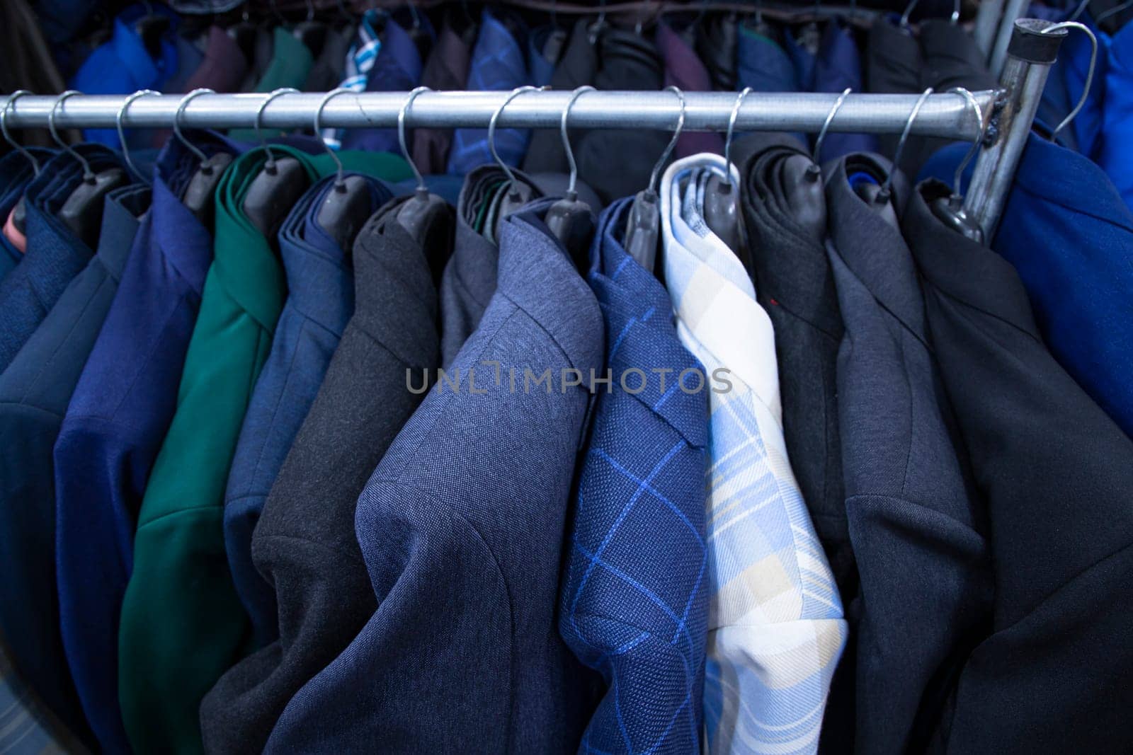 Men's clothing on hangers in a shop, closeup of photo