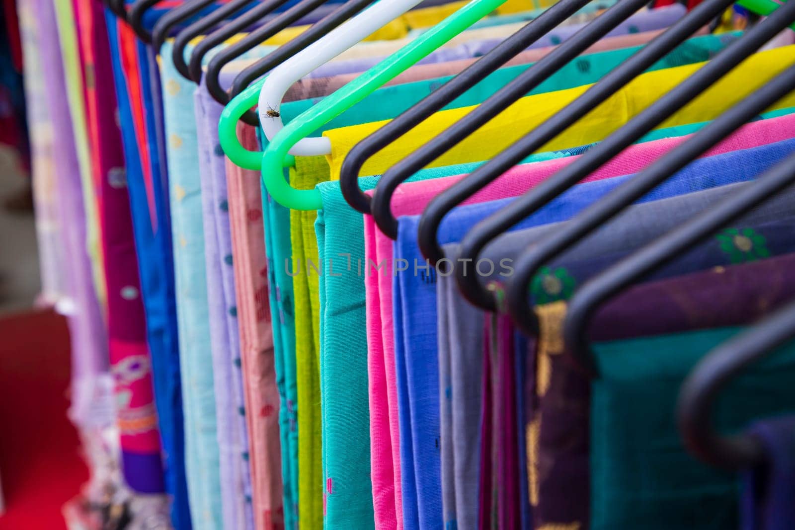 Colorful Saree clothes on hangers in a shop. Selective focus