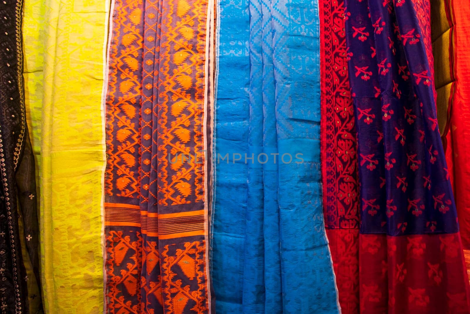 Bangladeshi Women's Traditional Colorful Jamdani saree hanging in the retail Showrooms. Colorful Jamdani Saree Texture Background