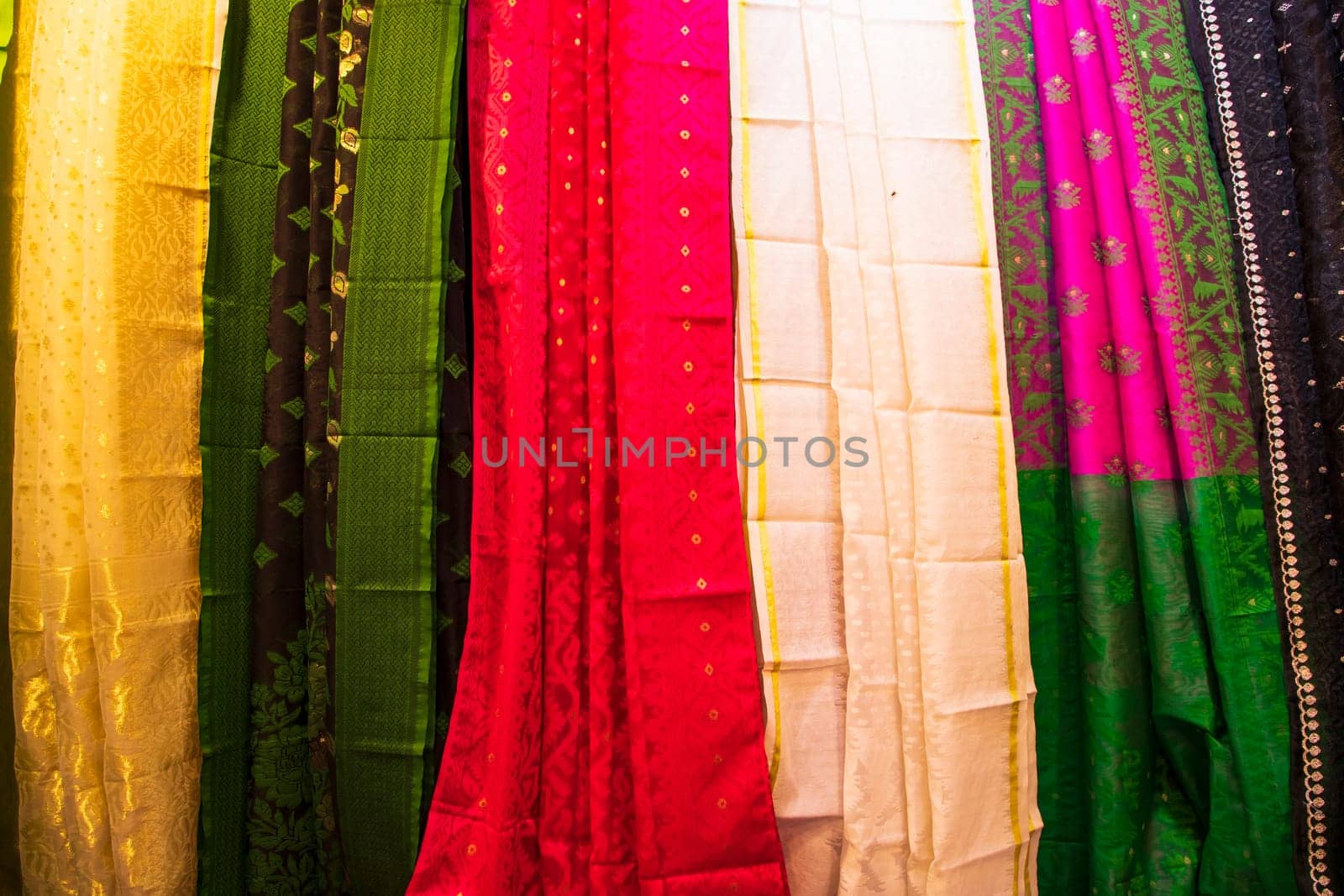 Bangladeshi Women's Traditional Colorful Jamdani saree hanging in the retail Showrooms. Colorful Jamdani Saree Texture Background