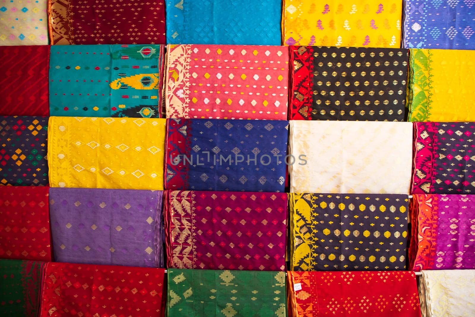 Bangladeshi Women,s Traditional Colorful Jamdani saree hanging in the retail Showrooms. Colorful Jamdani Saree Texture Background