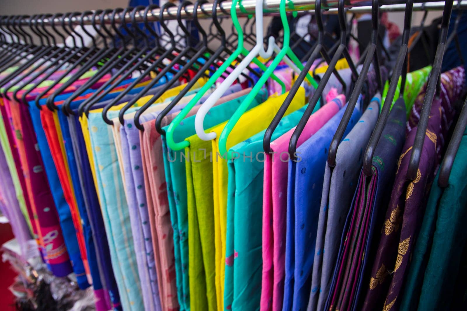 Colorful Saree clothes on hangers in a shop. Selective focus