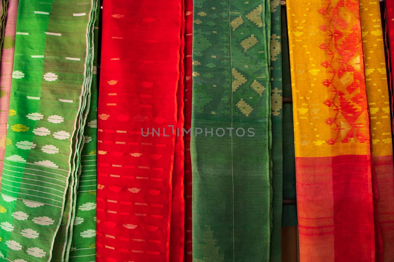 Bangladeshi Women,s Traditional Colorful Jamdani saree hanging in the retail Showrooms. Colorful Jamdani Saree Texture Background
