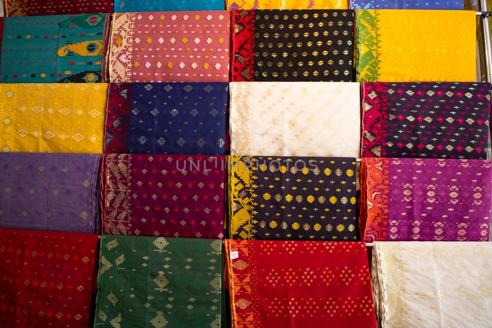 Bangladeshi Women,s Traditional Colorful Jamdani saree hanging in the retail Showrooms. Colorful Jamdani Saree Texture Background