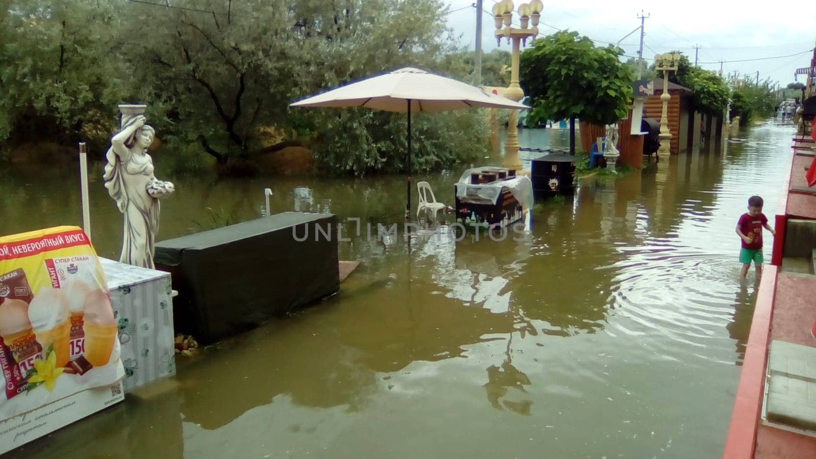 Anapa, Russia August 13 2021 Flooding caused by heavy rains and downpours. Consequences of a typhoon, cyclone or hurricane. Shopping street flooded with dirty water. Wet belongings and beach walkways