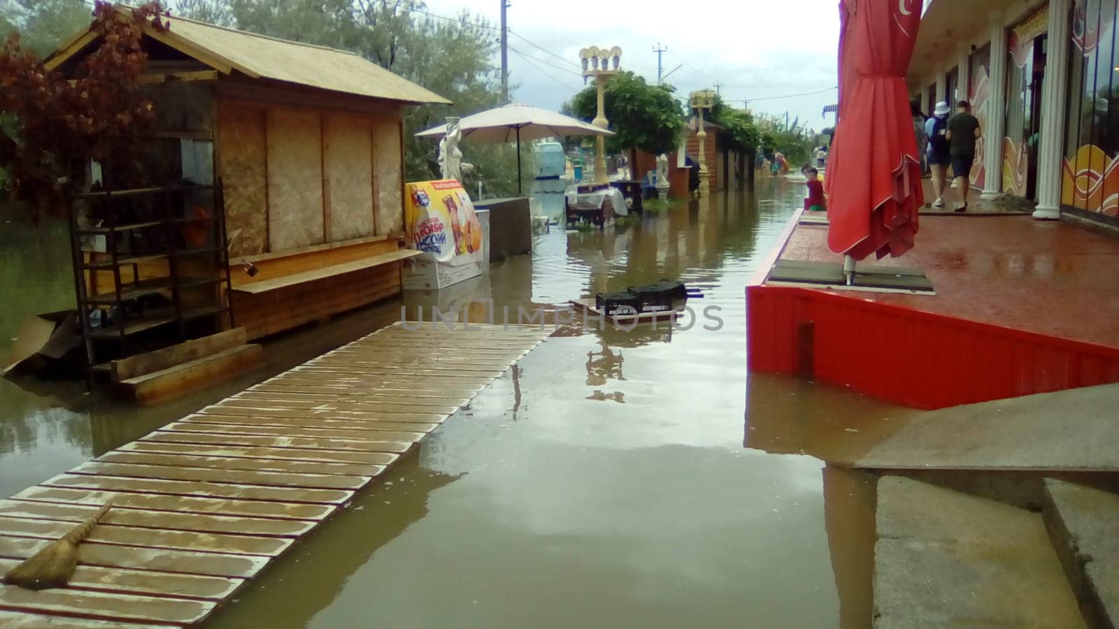 Anapa, Russia August 13 2021 Flooding caused by heavy rains and downpours. Consequences of a typhoon, cyclone or hurricane. Shopping street flooded with dirty water. Wet belongings and beach walkways
