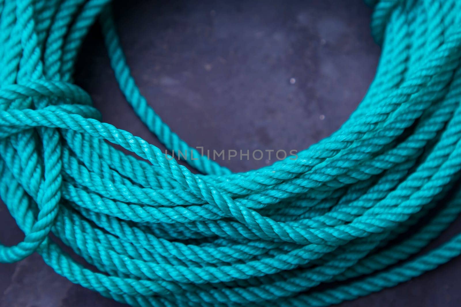 Green rope on the black background, closeup photo with selective focus