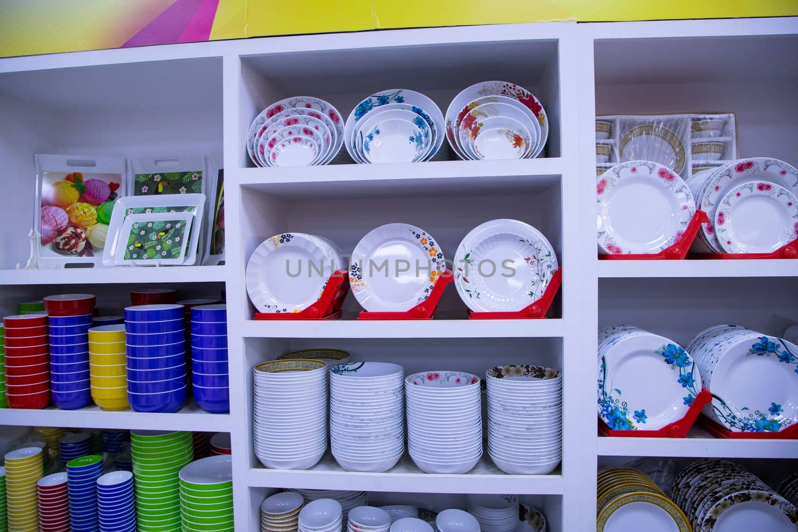 colorful ceramic tableware on the shelf in the shop, closeup