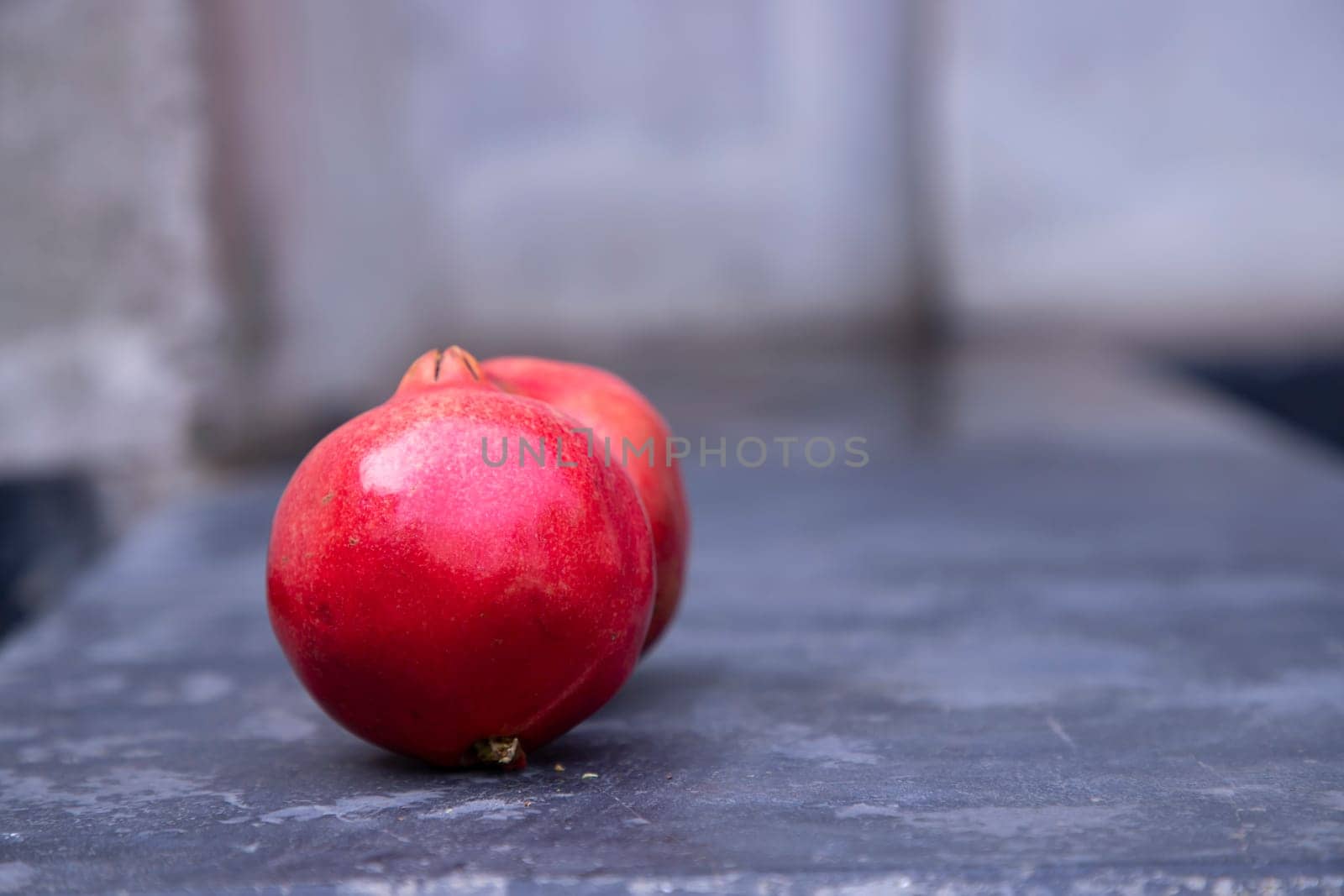 Ripe red pomegranate fruit on a dark background.