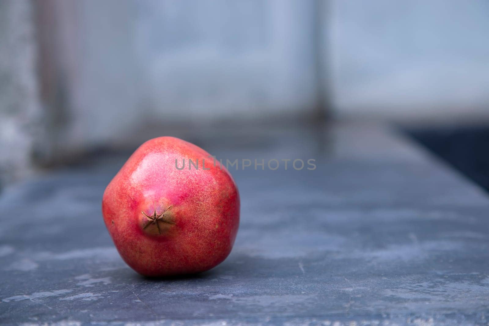 Ripe pomegranate on a stone table. Selective focus.