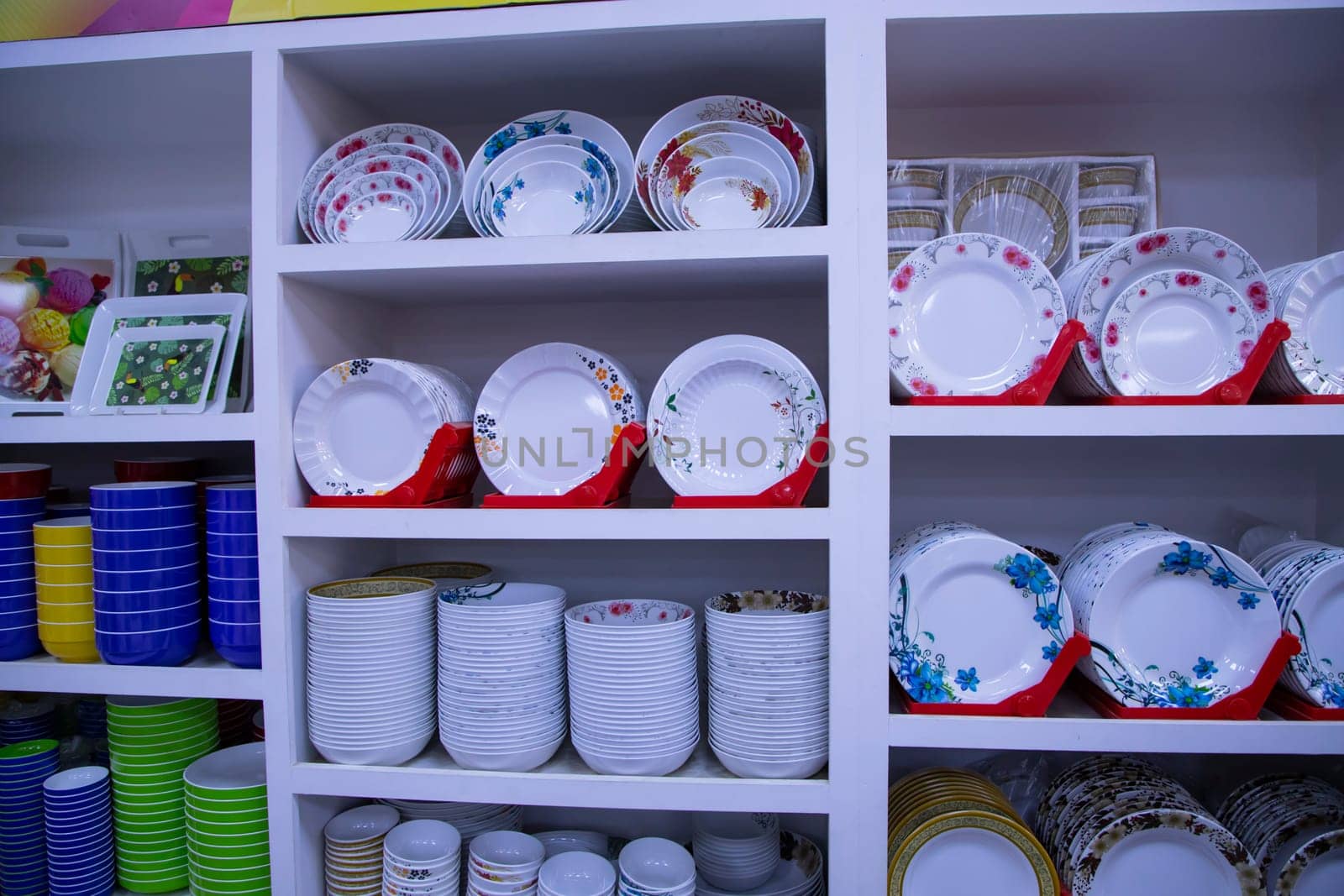 colorful ceramic tableware on the shelf in the shop, closeup